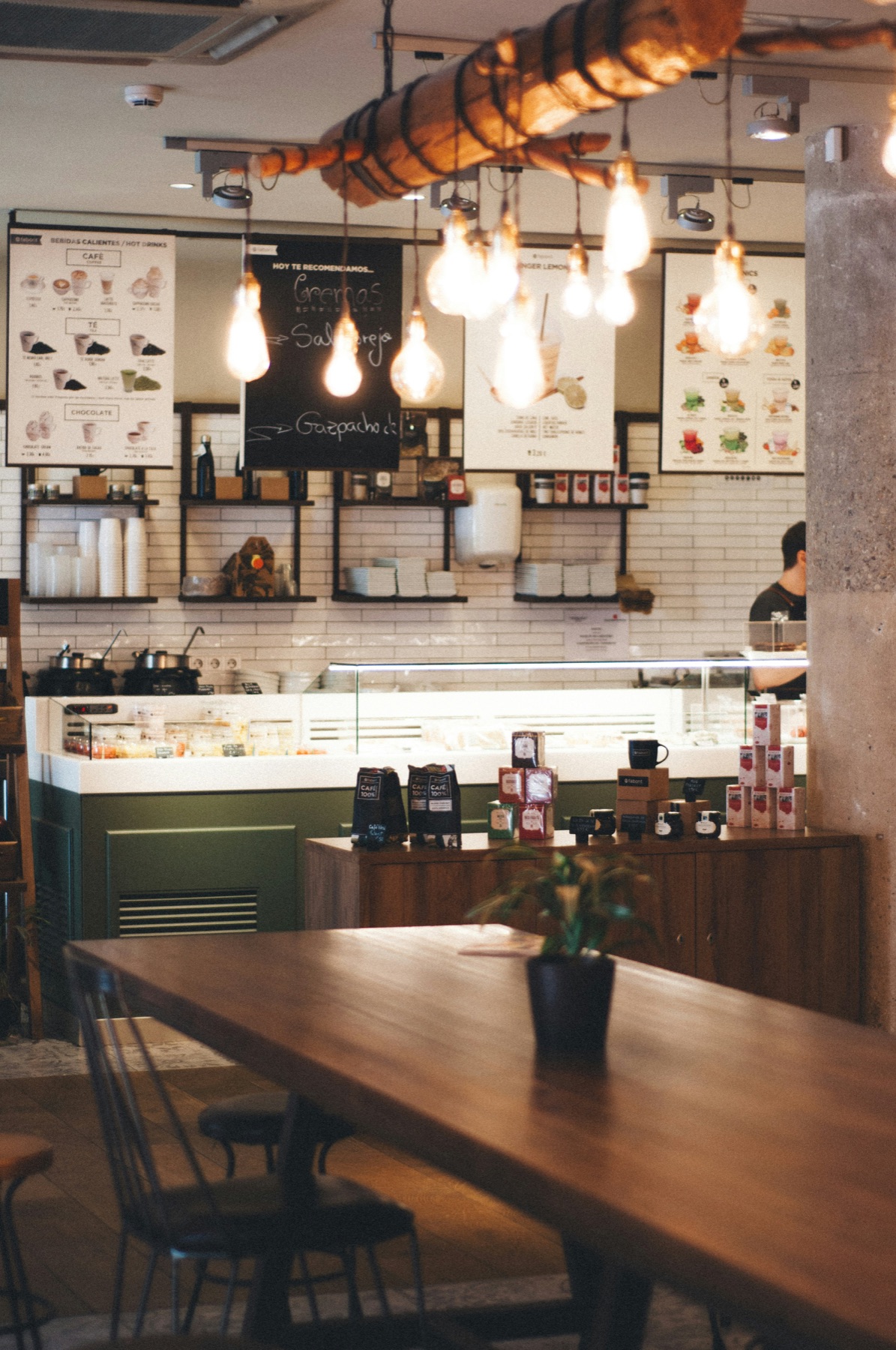 The counter under pendant lights, with a long wooden table in front
